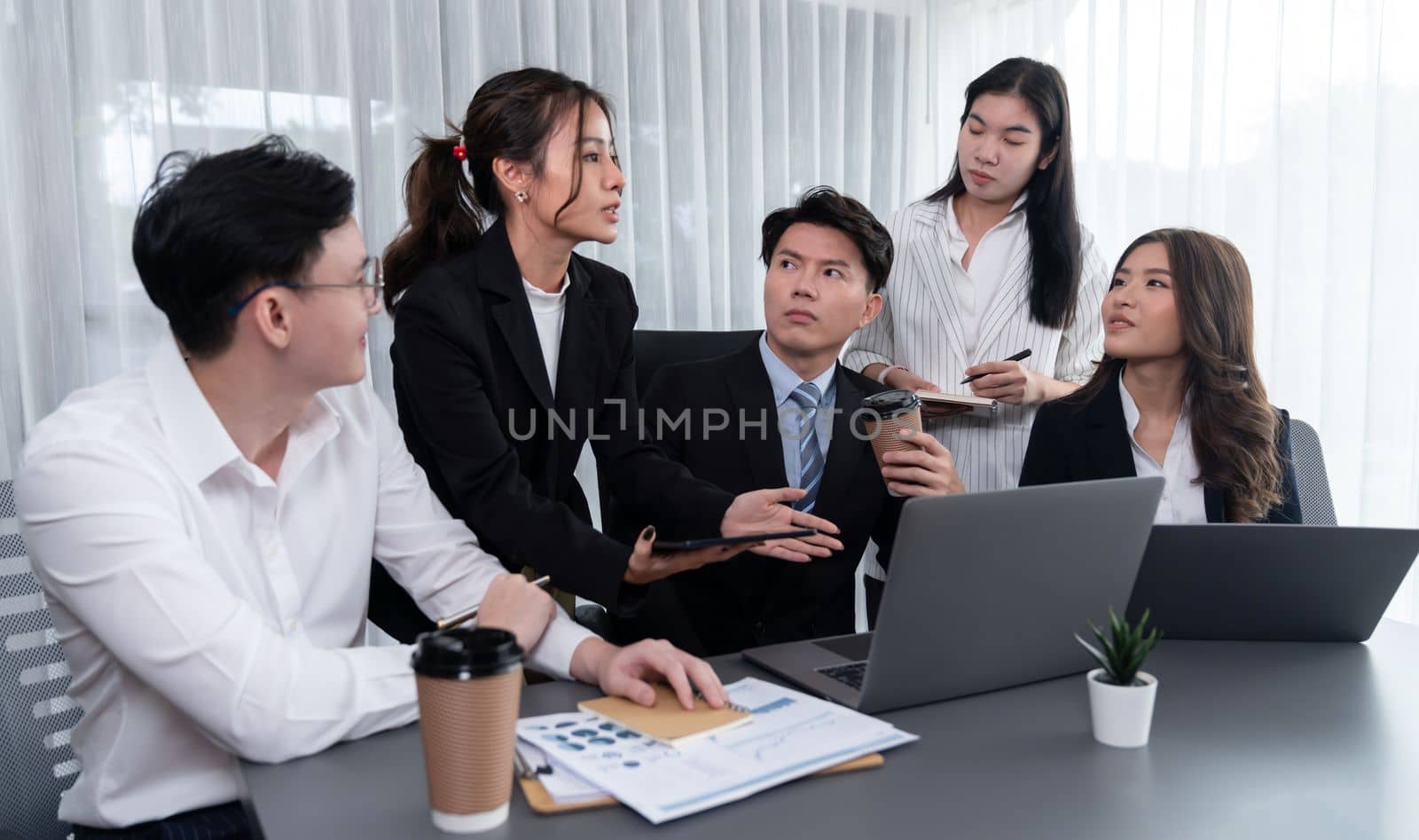 Harmony in office concept as business people analyzing dashboard paper together in workplace. Young colleagues give ideas at manager desk for discussion or strategy planning about project.