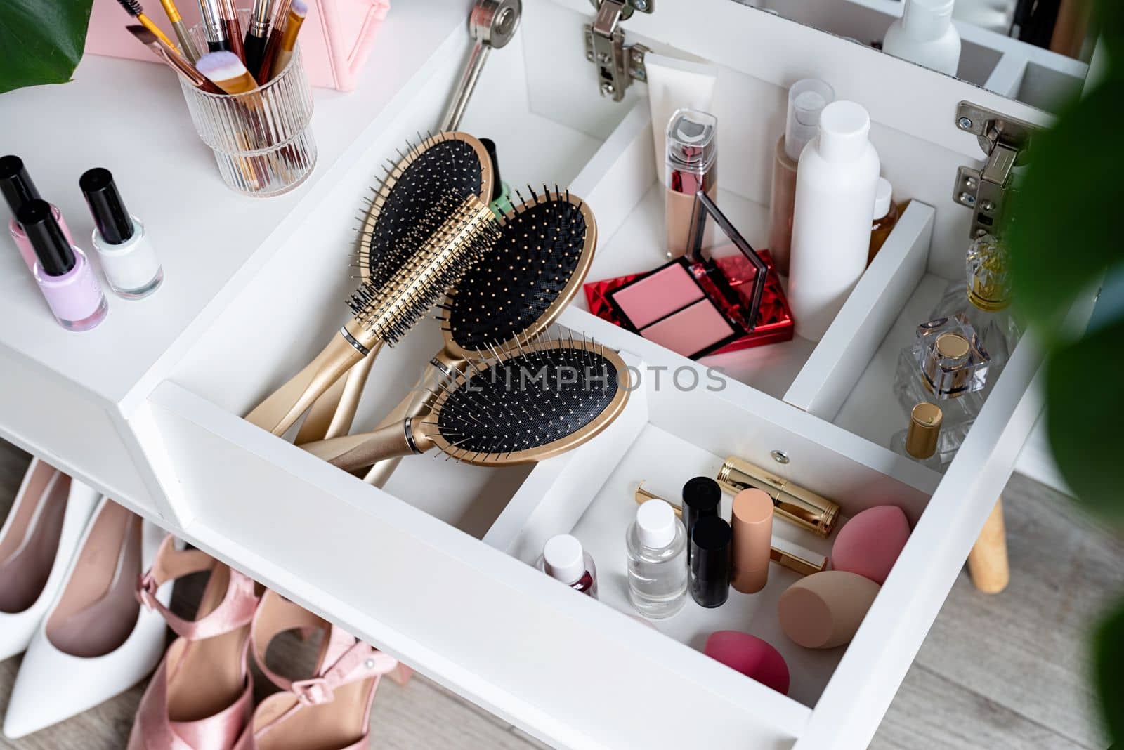 Stylish light room interior with elegant vanity table and plants, beauty and fashion. closeup of elegant high heel shoes standing under feminine dressing table
