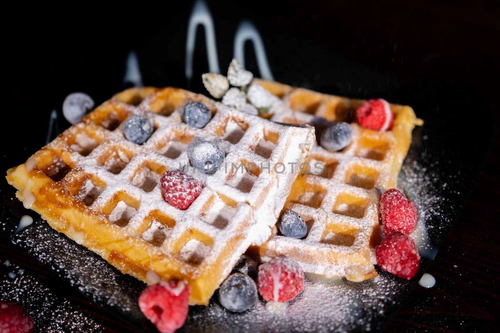 Delicious waffles with raspberries on table, closeup. High quality photo