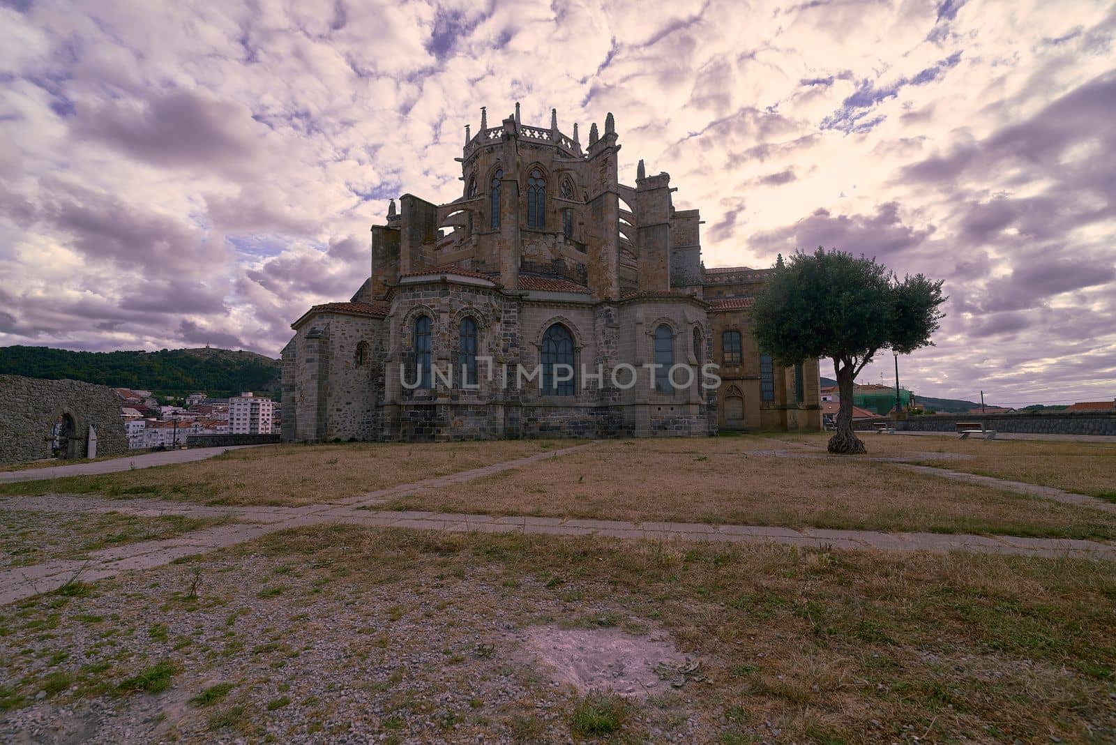 Castle of Santa Ana in Castro Urdiales. Cobblestone enclosure, , moving and escaping clouds, tree, sunset, sunny, buildings