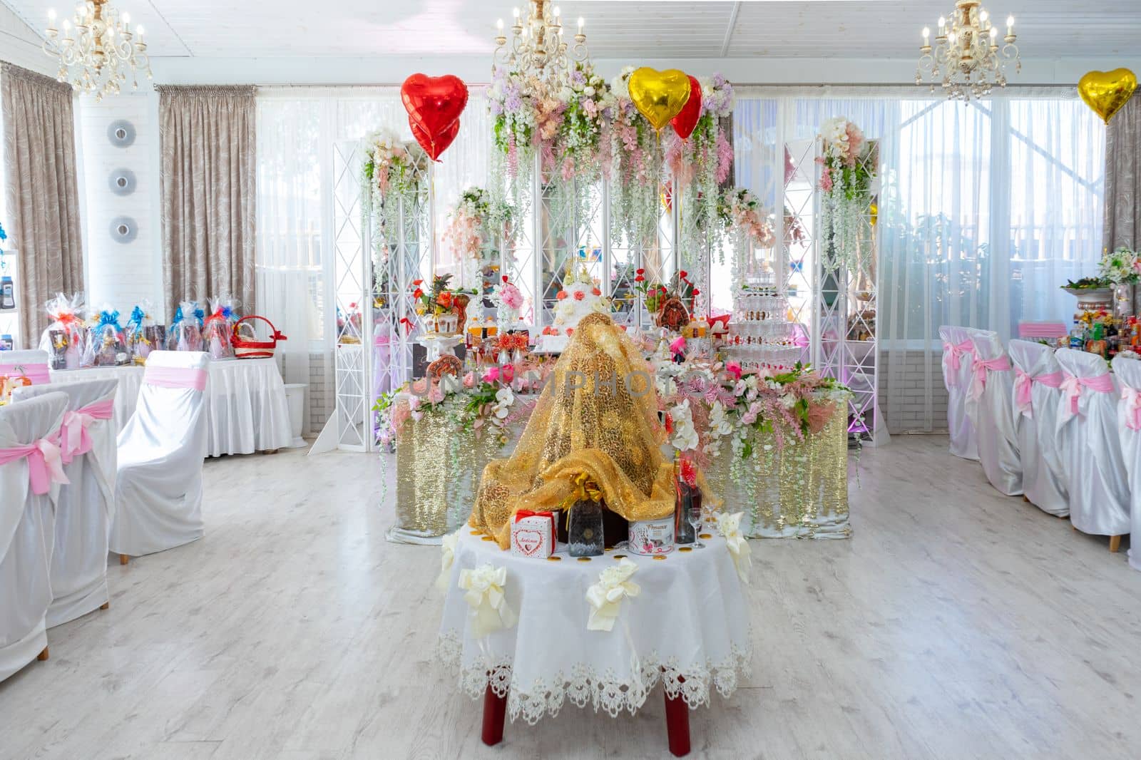 A table for ransoming the bride at a gypsy wedding. The wedding table of the bride and groom is decorated with many different flowers. Ukraine, Vinnytsia, August 10, 2021