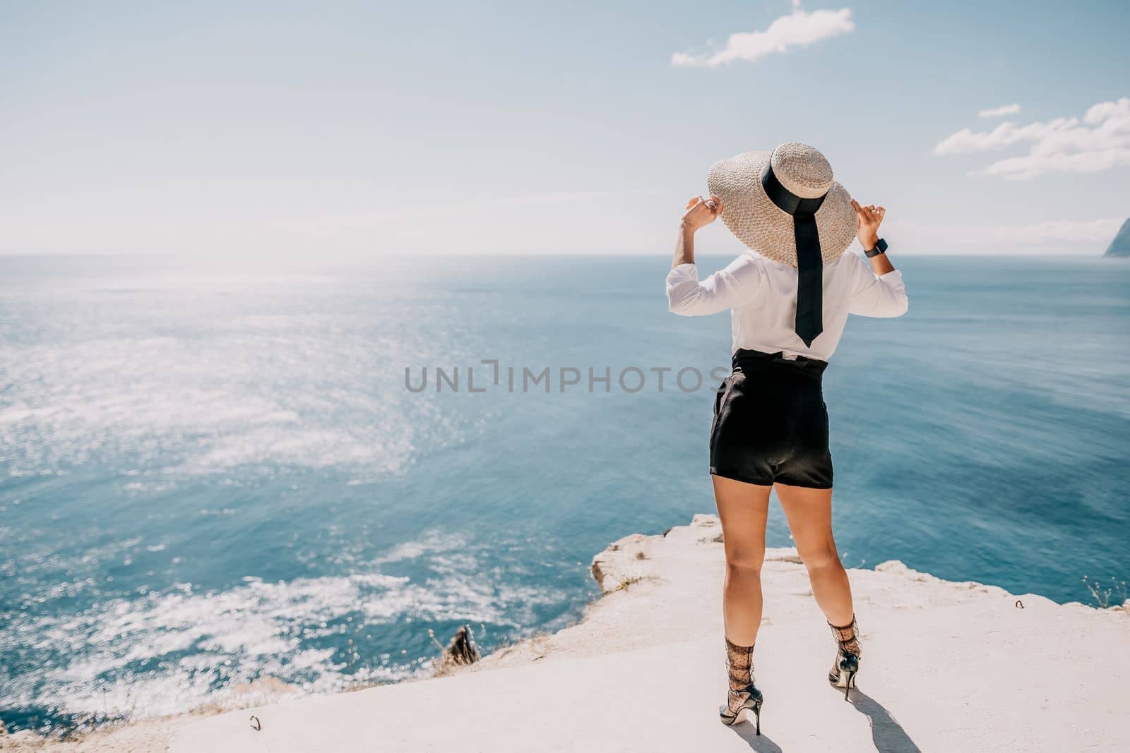 Woman sea hat. Business woman in yellow hat freelancer working over blue sea beach. Girl relieves stress from work. Freelance, digital nomad, travel and holidays concept by panophotograph