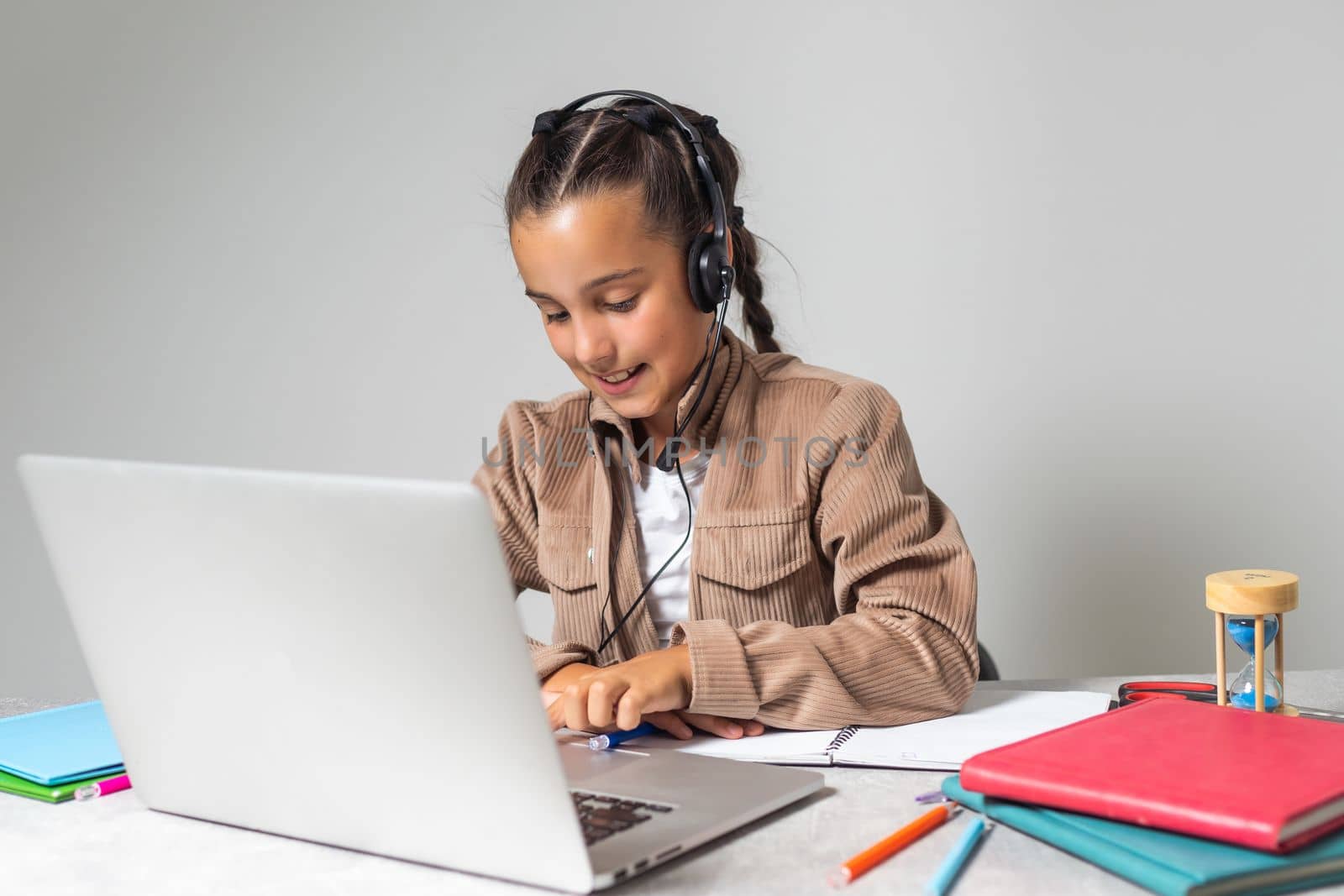 Online Education. Cute little Girl Study At Home With Laptop And Wireless Headphones, Adorable Kid Having Web Lesson With Teacher, Enjoying Distance Learning During Quarantine Time, Free Space.