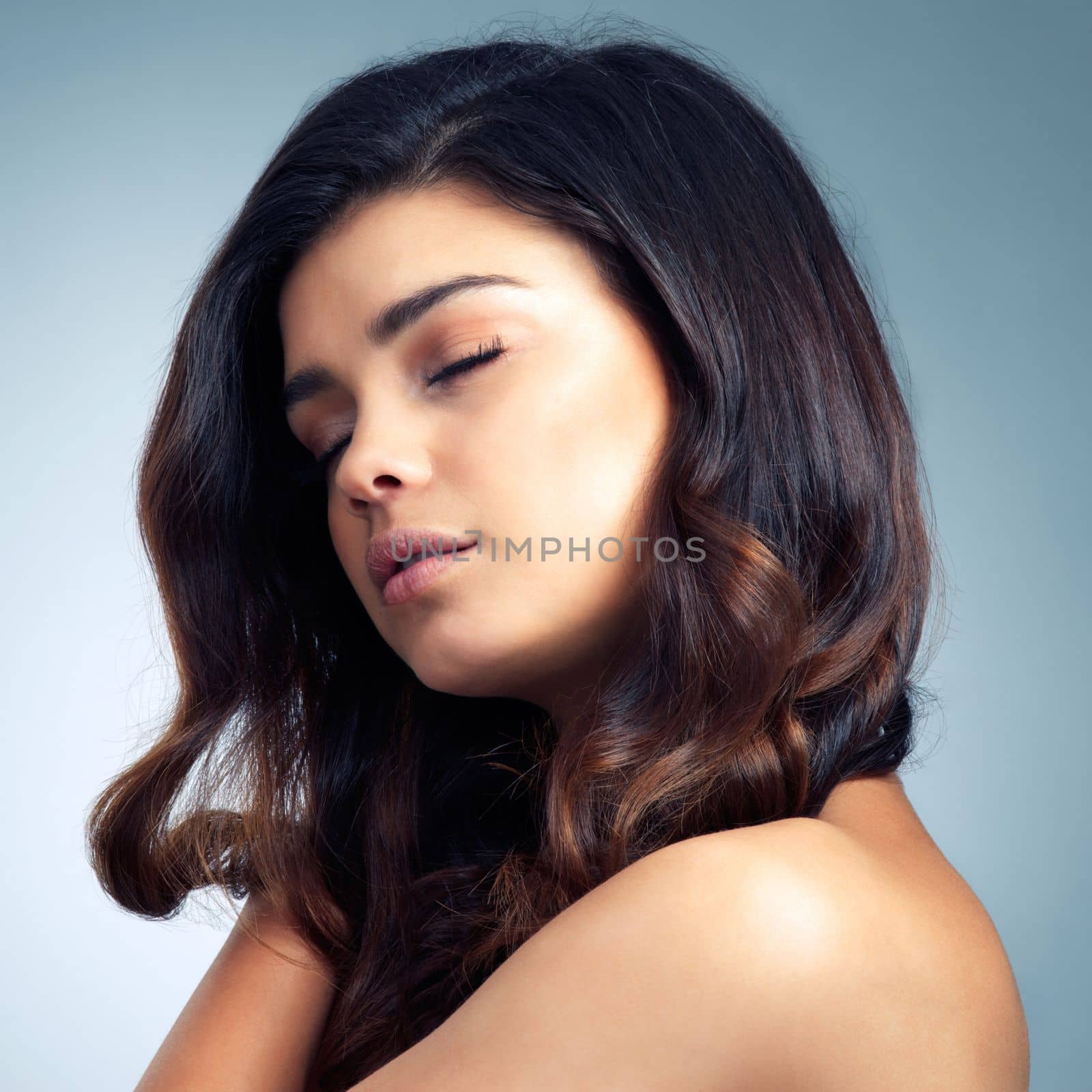 Beauty doesnt get any more beautiful than her. Studio shot of a beautiful young woman posing against a gray background