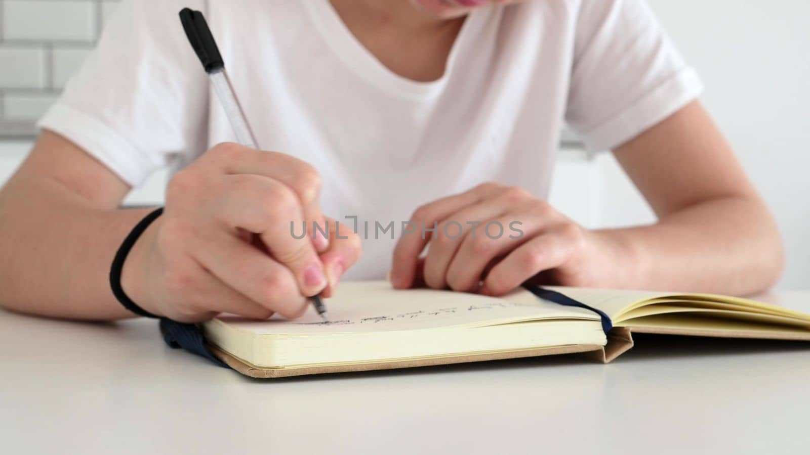 Girl writing in notebook diary with pen. Female teenager creating letter and share ideas on paper handwriting