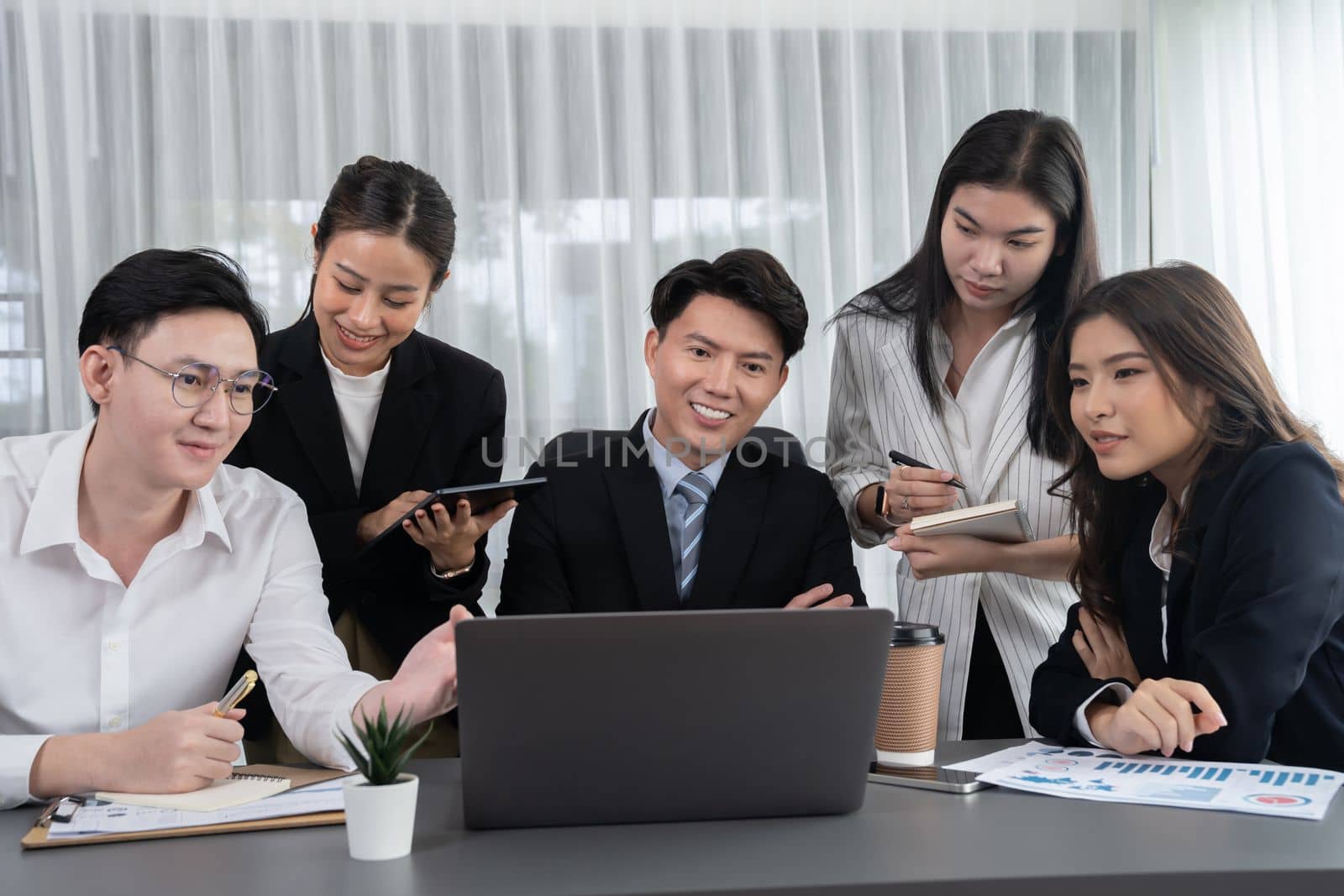 Harmony in office concept as business people analyzing dashboard paper together in workplace. Young colleagues give ideas at manager desk for discussion or strategy planning about project.