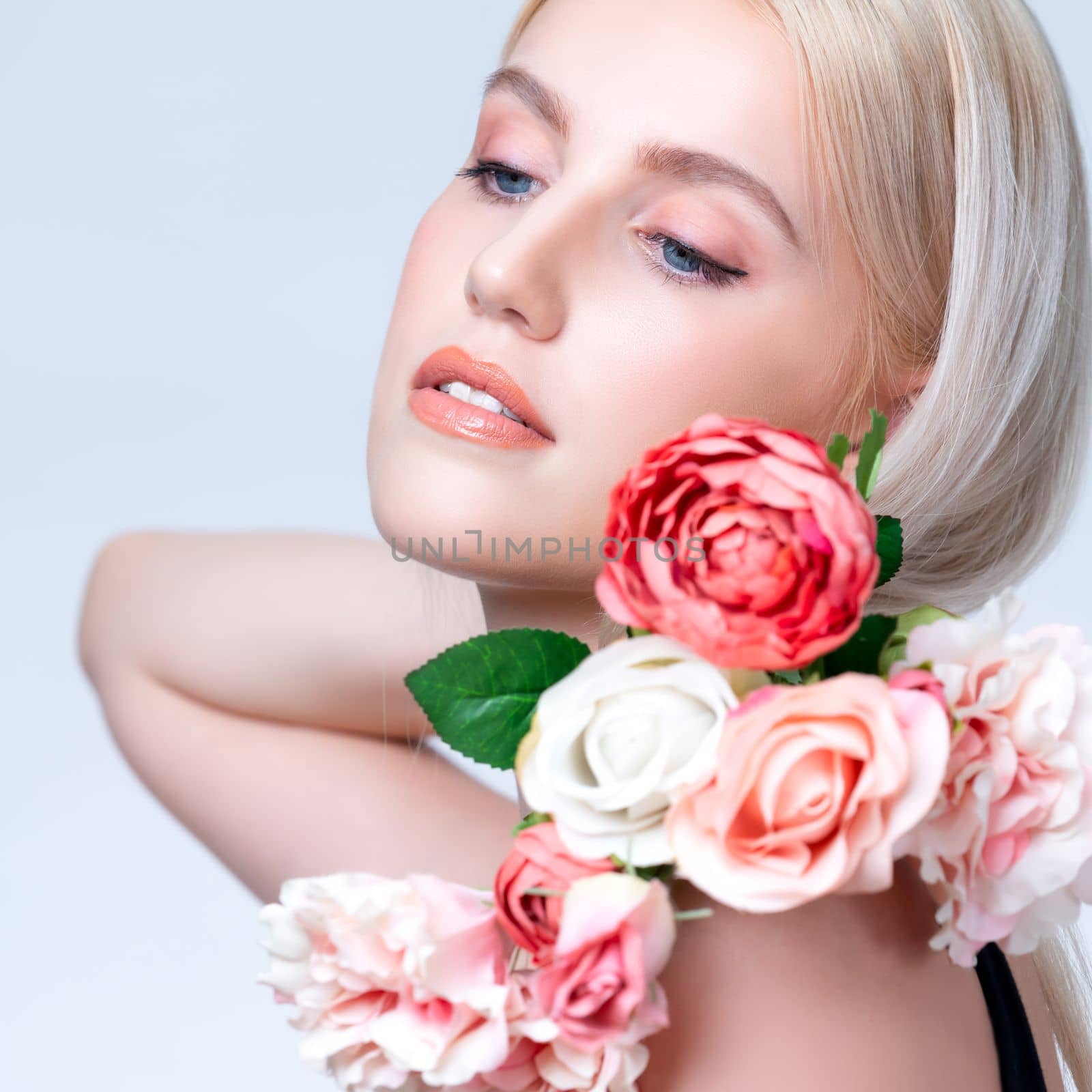 Closeup young personable woman with flawless makeup holding flower. by biancoblue