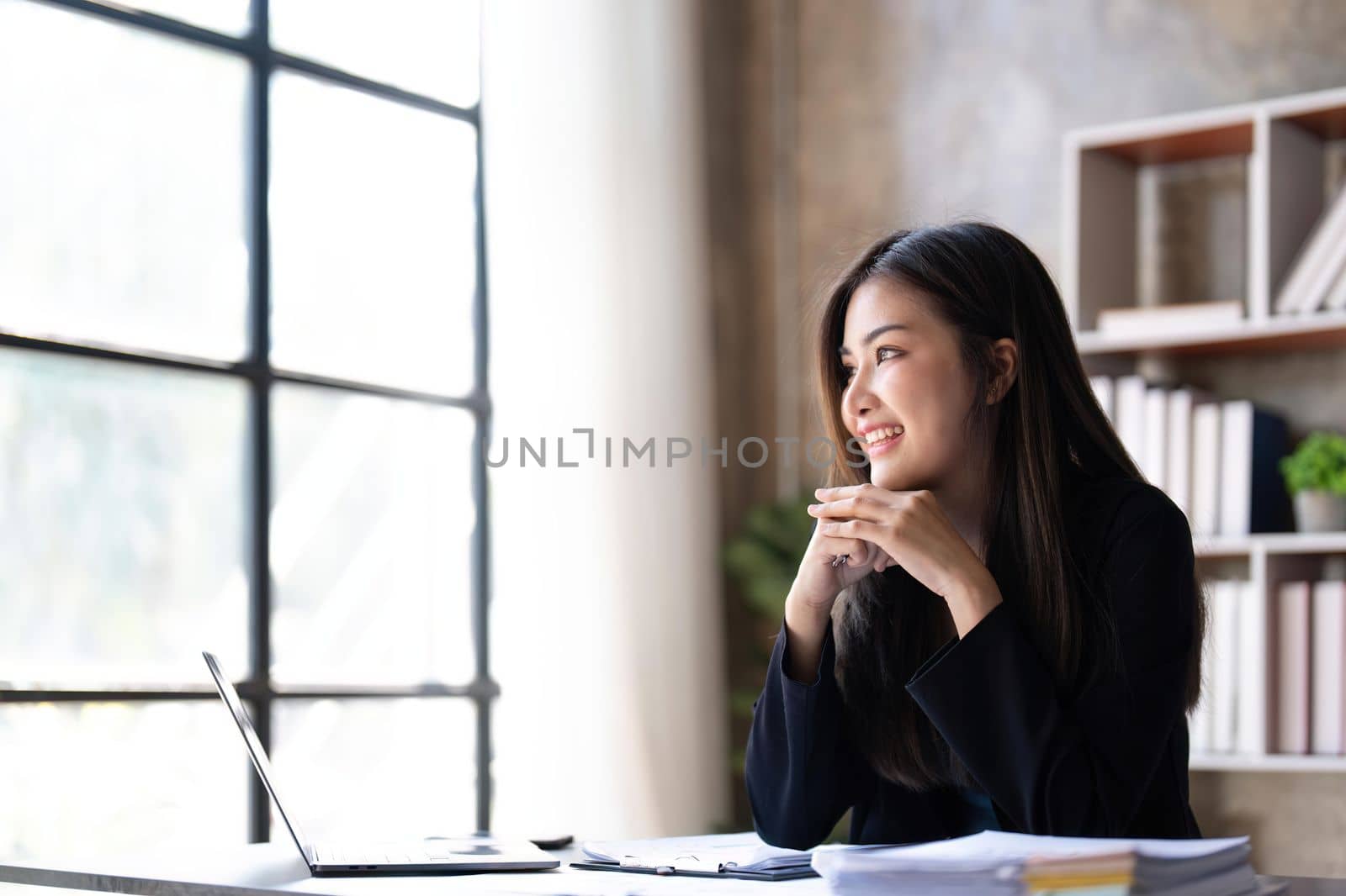 Young beautiful businesswoman working on laptop and There are documents on the table at bright modern office.