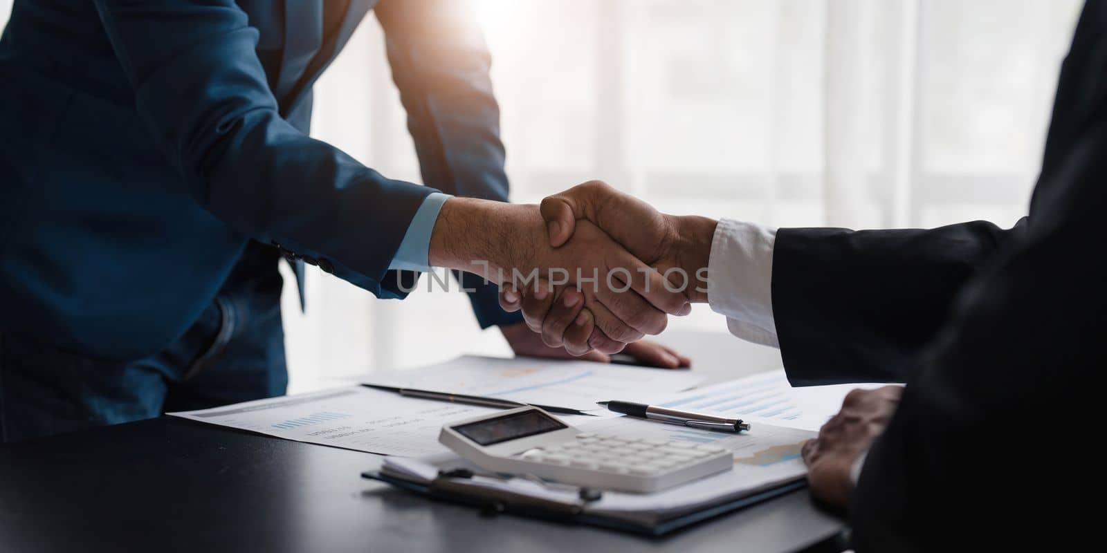 Business handshake for teamwork of business merger and acquisition,successful negotiate,hand shake,two businessman shake hand with partner to celebration partnership and business deal concept. by wichayada