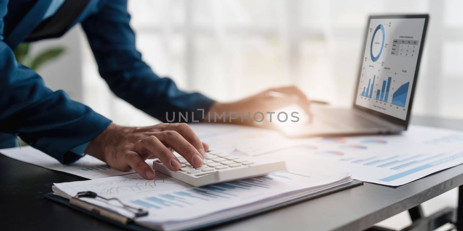 Close up Businessman using calculator and laptop for calculating finance, tax, accounting, statistics and analytic research concept..