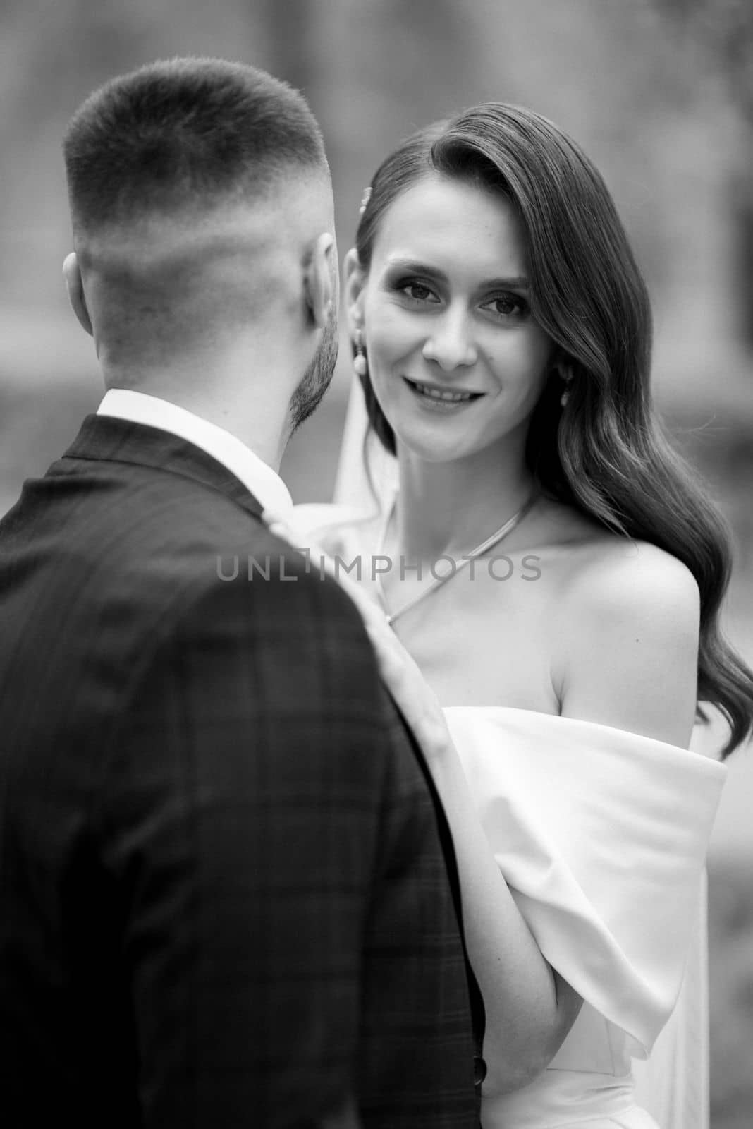 newlyweds walk in the park among cherry blossoms by Andreua