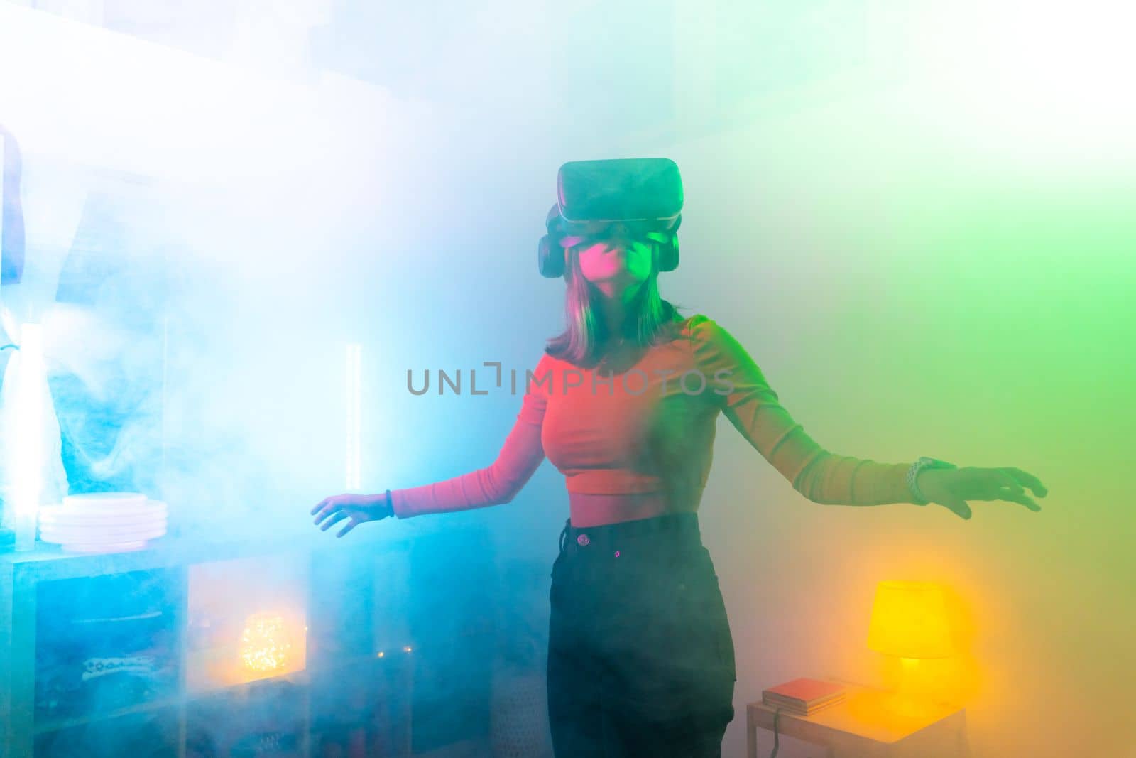 Young woman using virtual reality glasses in the dark room with neon lighting. Wireless technologies. by PaulCarr