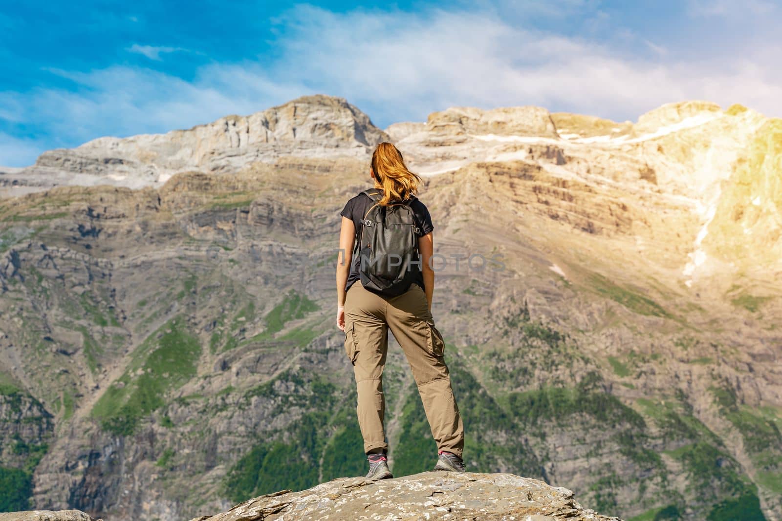 Young Woman With A Backpack on The Top Of a rock in a Beautiful wild Landscape. Discovery Travel Destination Concept. High quality photo