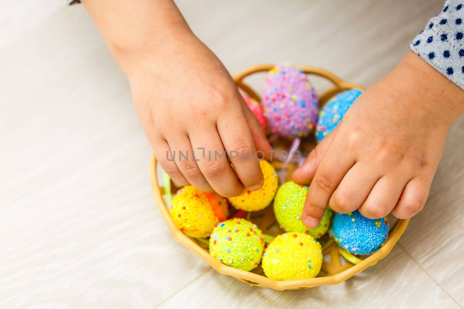 Cute smiling little girl with basket full of colorful easter eggs by Andelov13