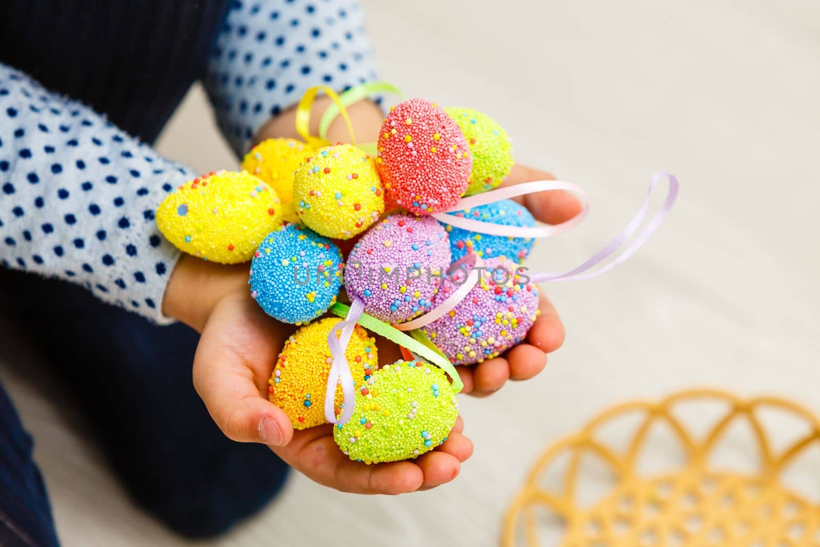 Cute smiling little girl with basket full of colorful easter eggs