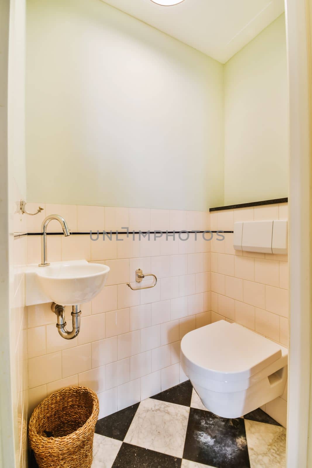 a bathroom with black and white checkered tiles on the floor, sink and toilet in the room is empty