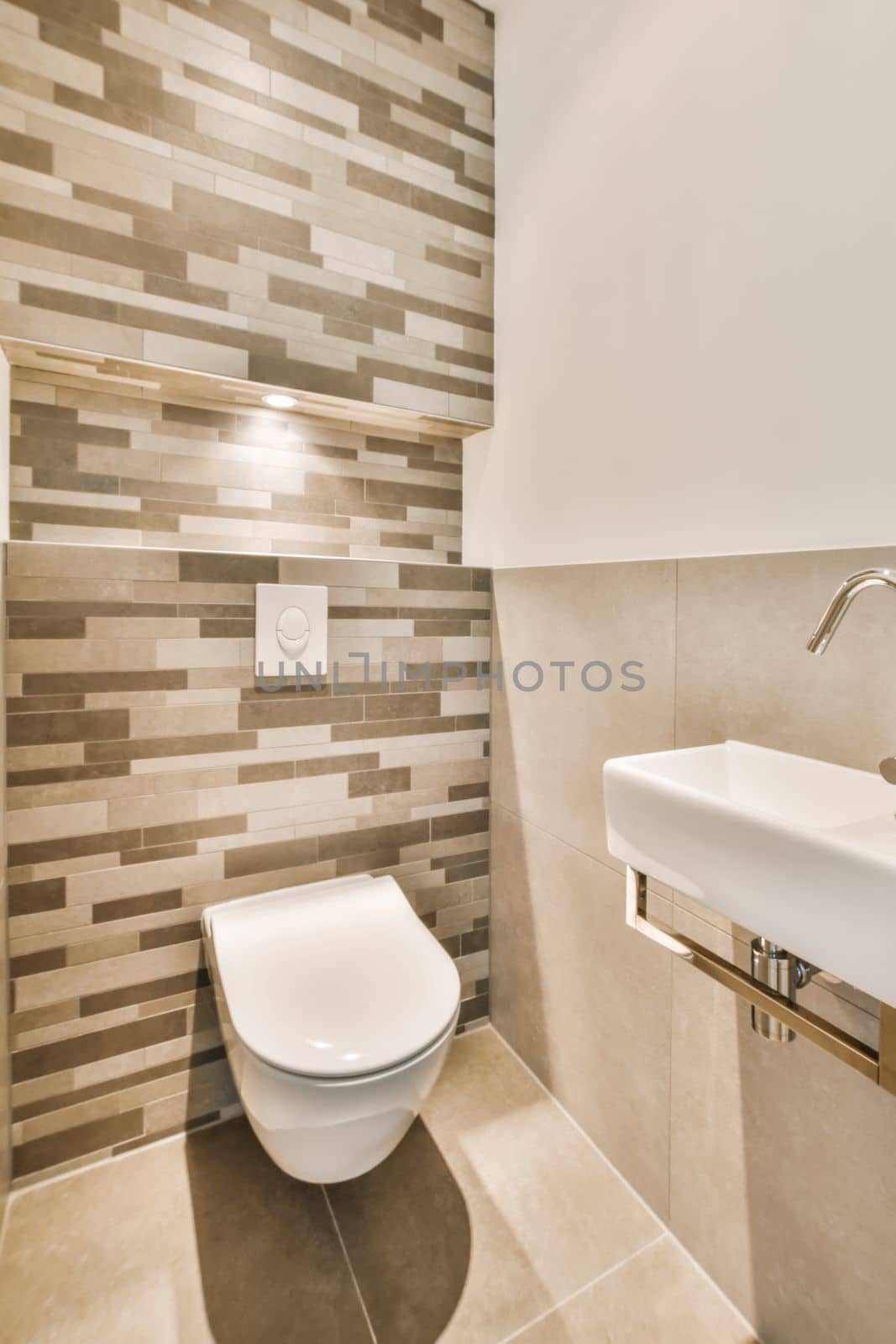 a white toilet in a bathroom with tile on the walls and wall behind it is a sink that has been installed