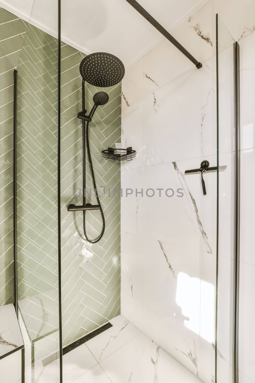 a bathroom with green tiles and black shower faucets on the wall next to it is a white tiled floor