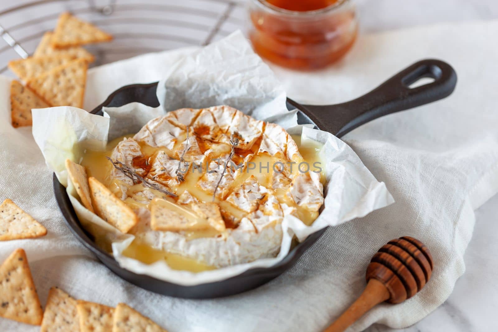 camembert soft french cheese cooked in the oven with honey and thyme, side view