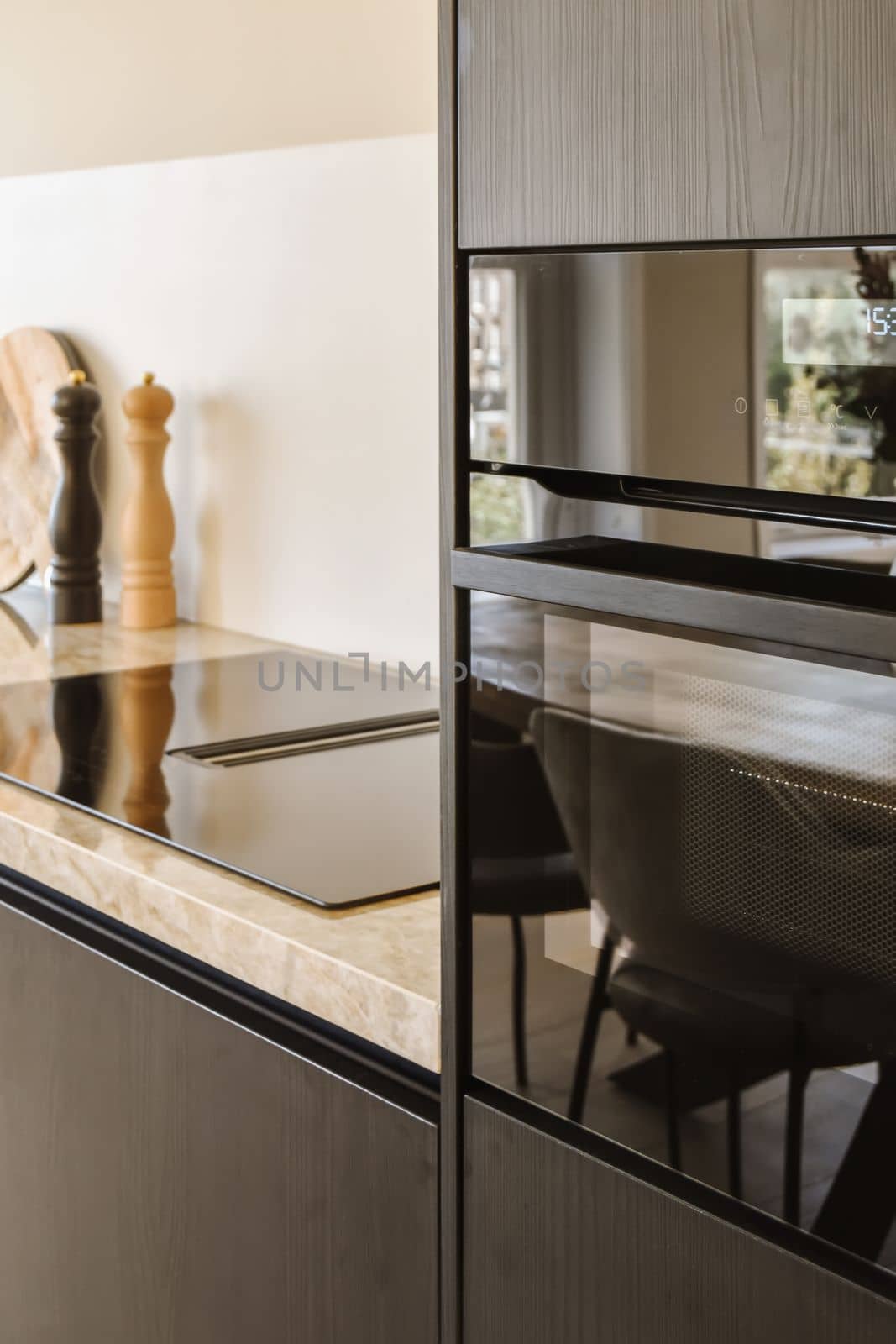 a kitchen with an oven in the middle and chairs on the other side of the counter area behind it, there is a vase