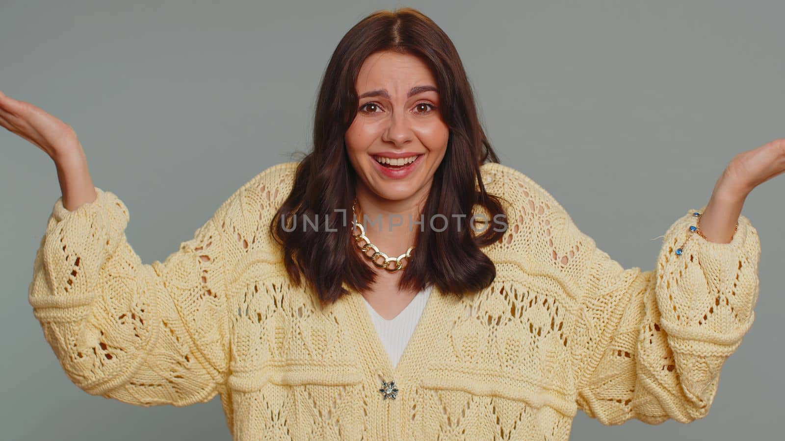 What Why. Sincere irritated woman raising hands in indignant expression asking reason of failure demonstrating disbelief irritation by trouble. Young confused pretty girl isolated on gray background