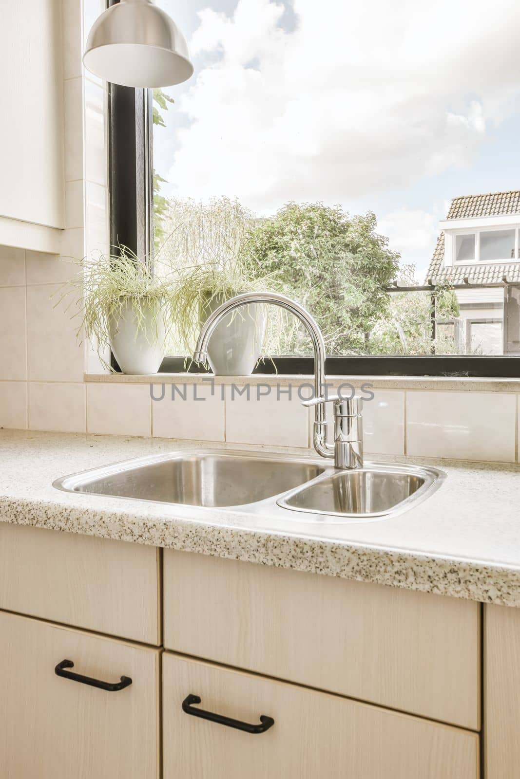 a kitchen counter with a sink and a window by casamedia