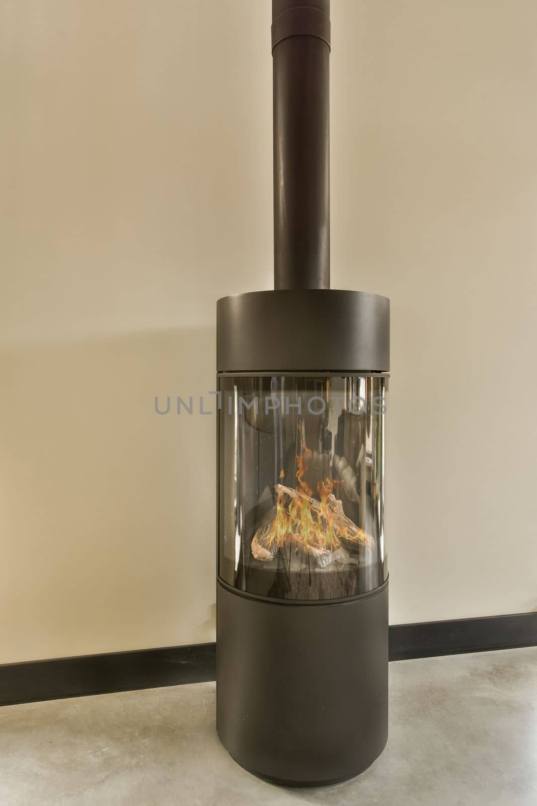 a wood burning stove in the corner of a room with white walls and black trim on the wall behind it