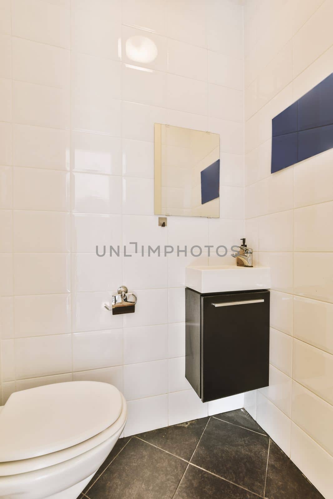 a modern bathroom with black and white tiles on the floor, sink and toilet in the photo is taken from above