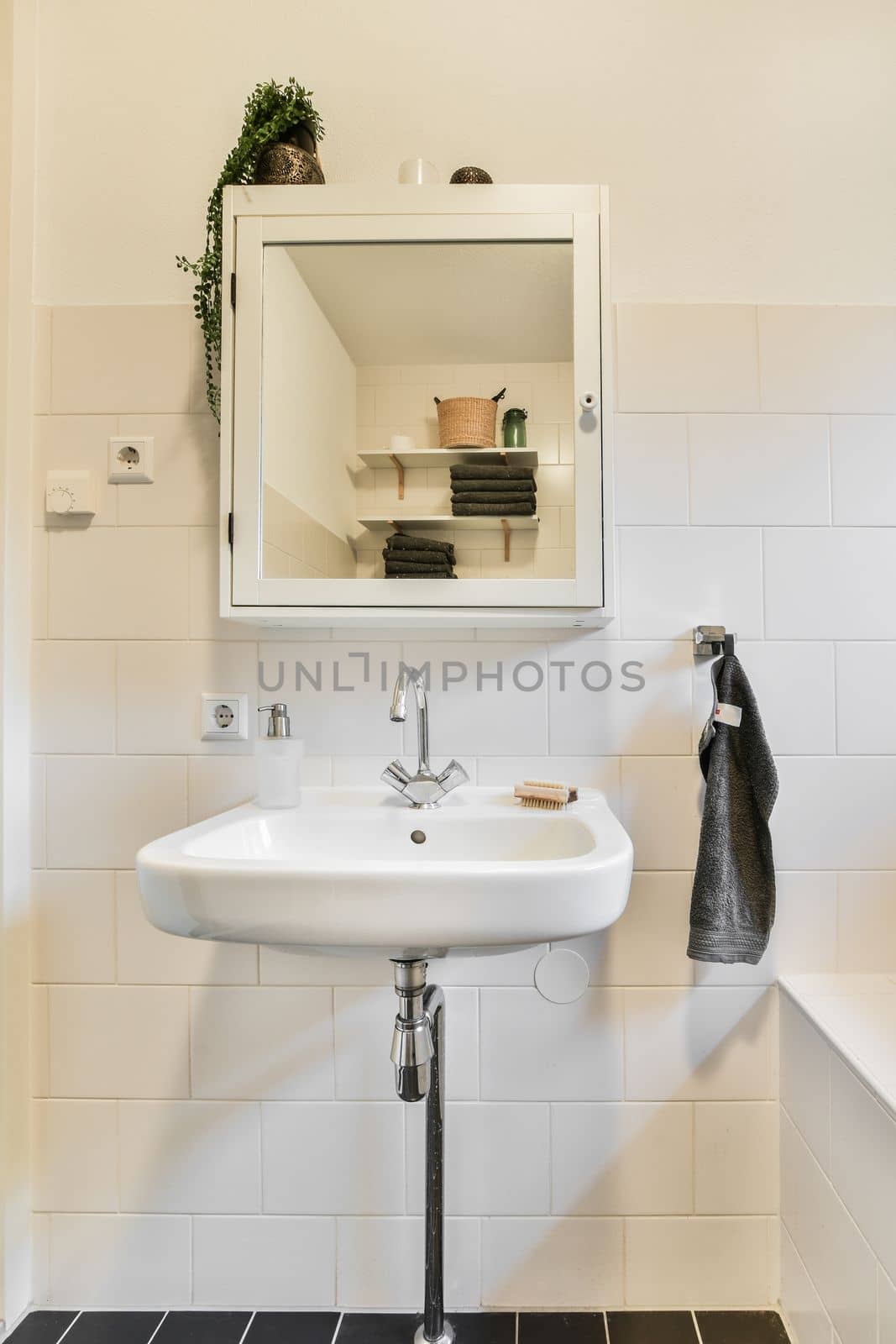 a bathroom with a sink, mirror and towel hanging on the wall in front of the sink is black and white