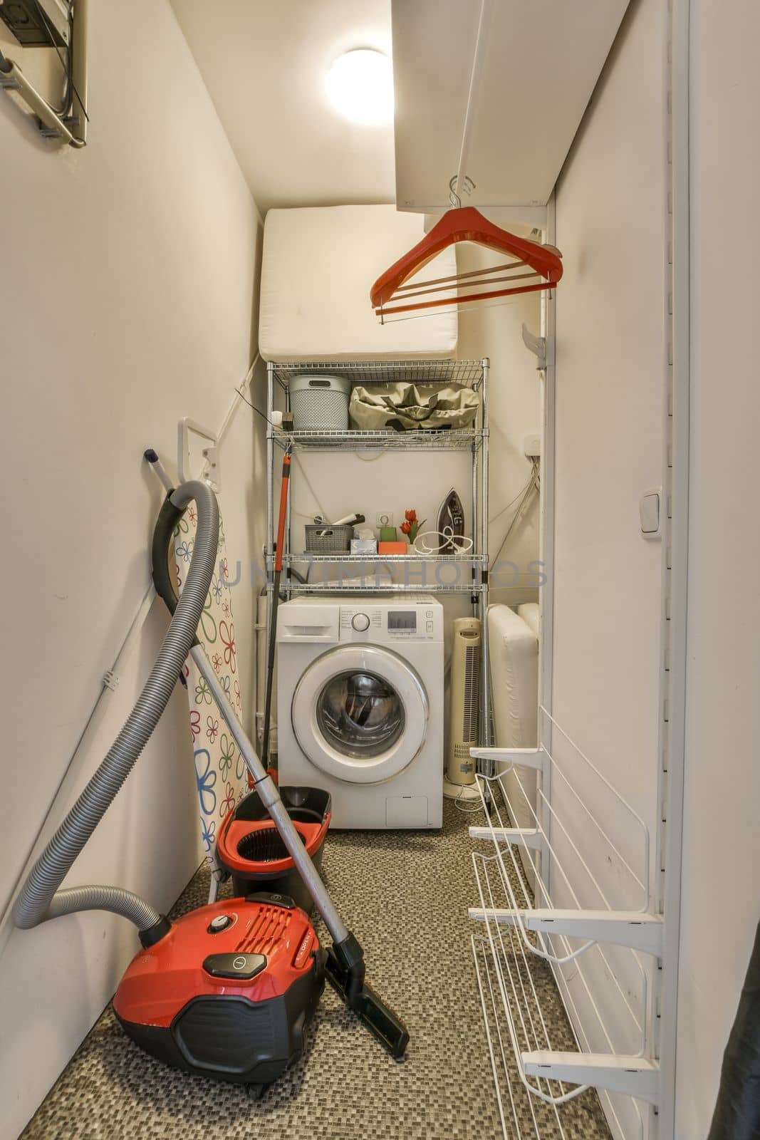 a small bathroom with a washing machine and a vacuum by casamedia