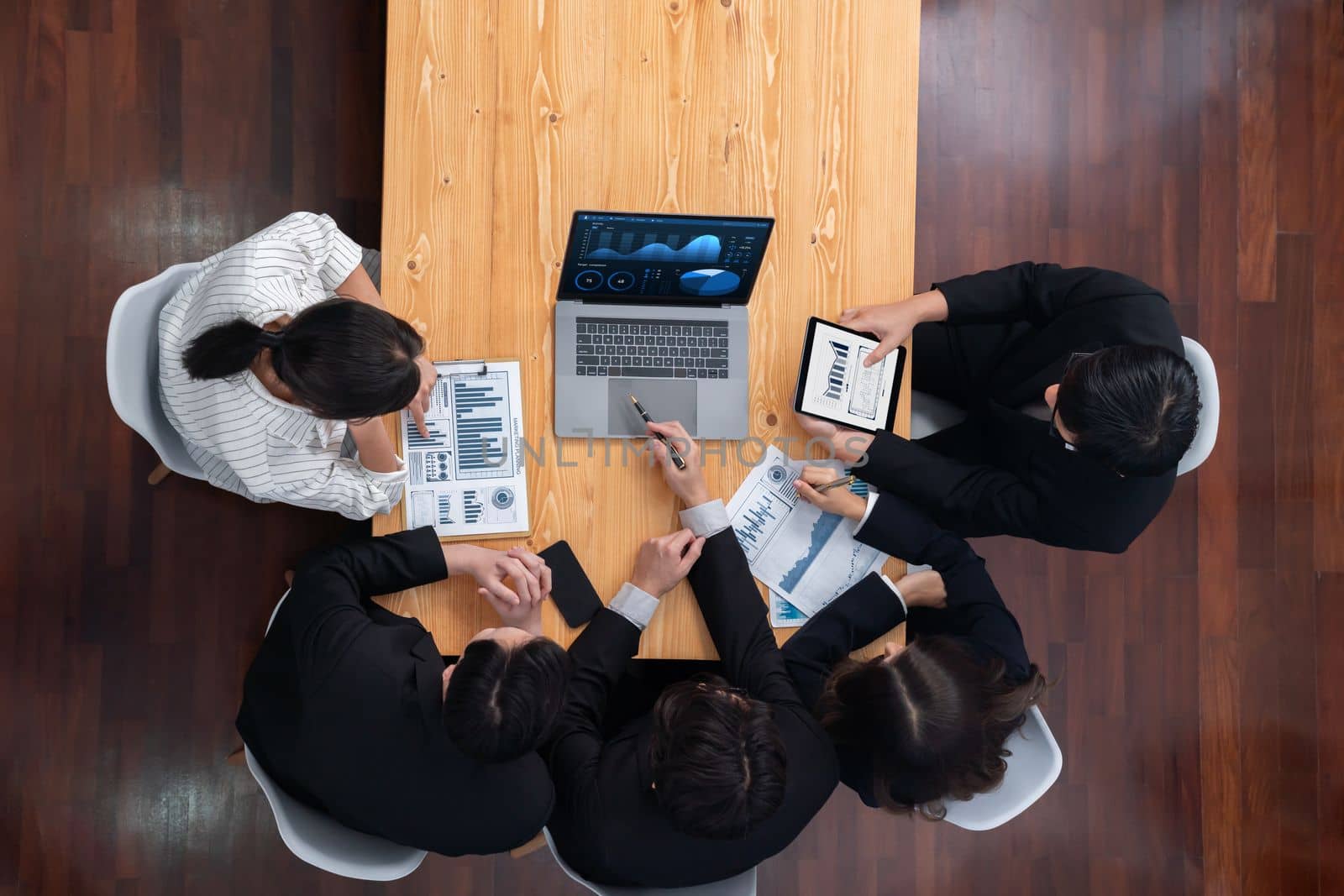 Top-view business team of financial data analysis meeting with business intelligence, report paper and dashboard on laptop for marketing strategy. Business people working together in office of harmony