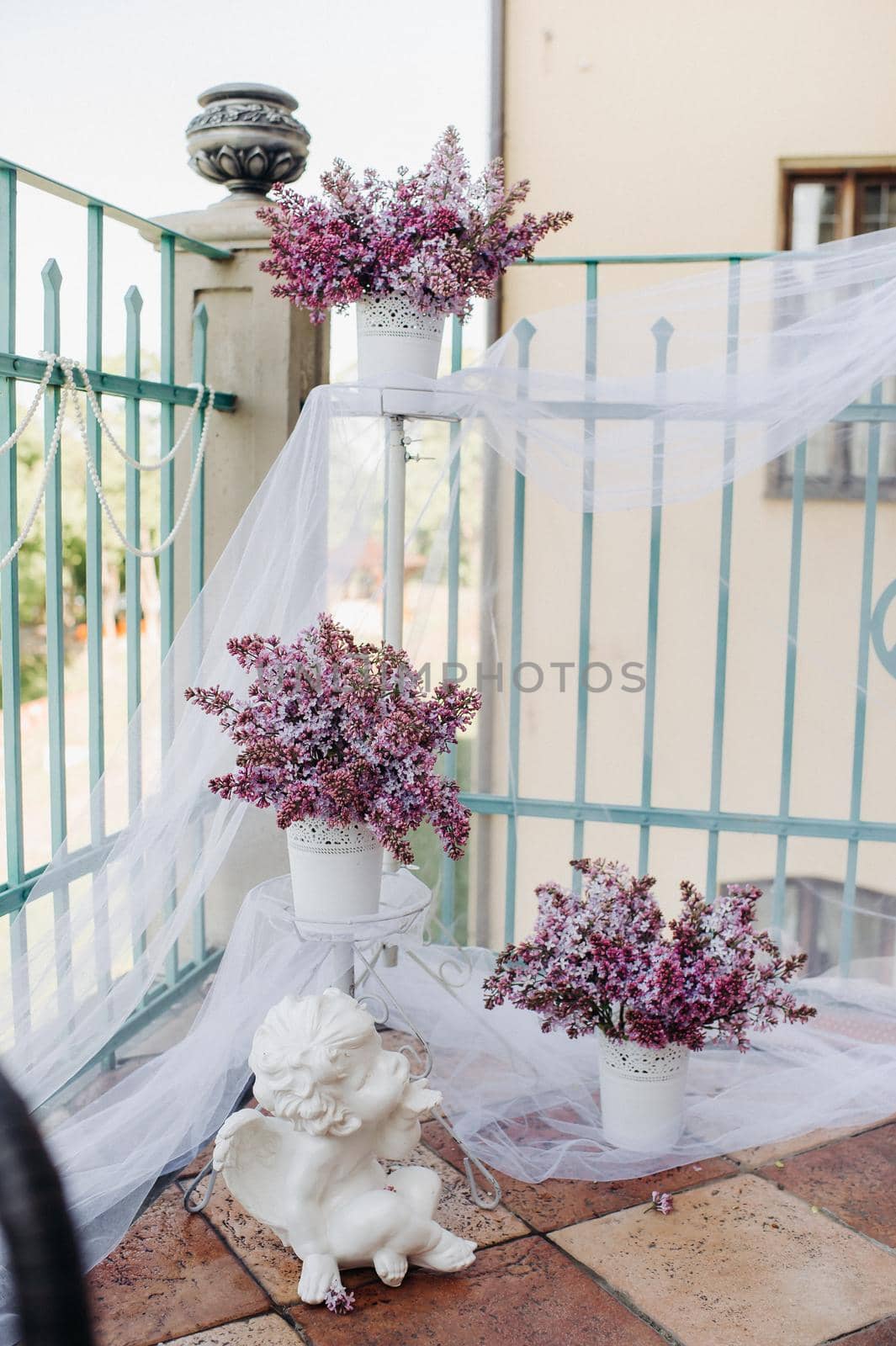 Delicate morning tea table setting with lilac flowers in Nesvizh castle, antique spoons and dishes on the table with a pink tablecloth.