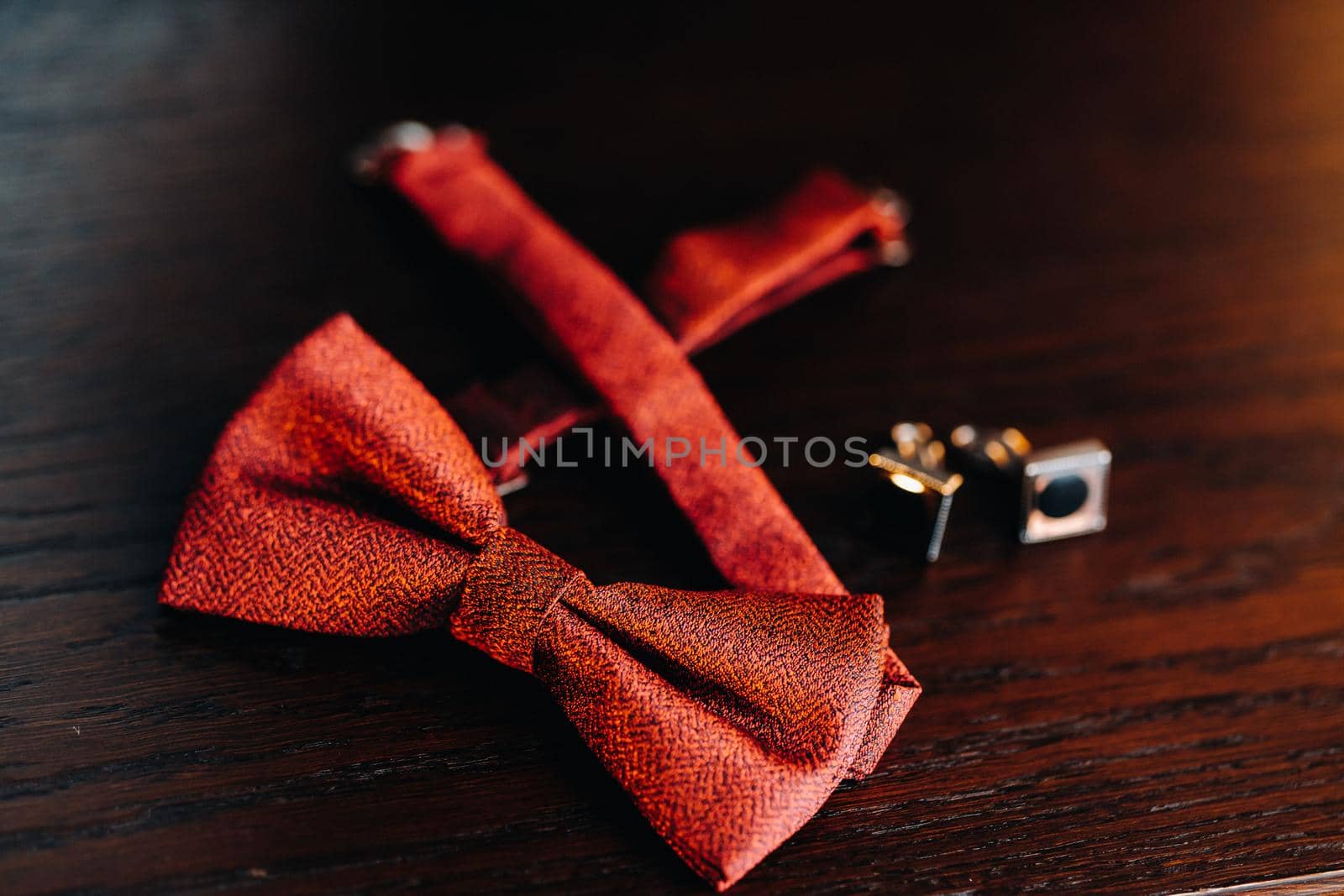 Classic Groom Accessories: red bow tie and cufflinks on the table. Morning of the groom.