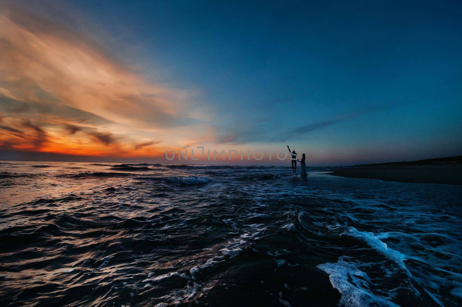A couple in love at sunset on the background of the sea, an unrecognizable couple Portrait of a beautiful newlywed couple expecting a child. Photo, by Lobachad