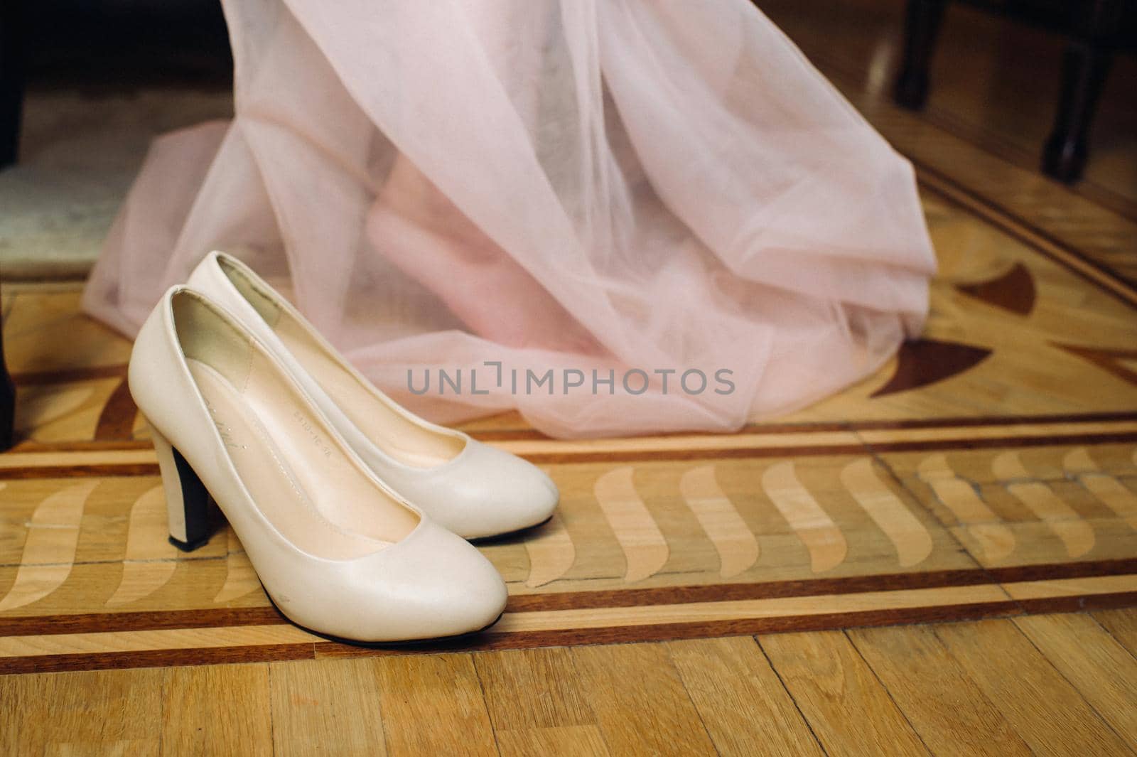 white wedding shoes standing on the field near the dress.