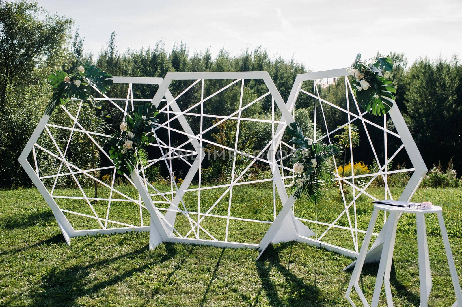 Wedding ceremony on the street on the green lawn.Decor with fresh flowers arches for the ceremony.