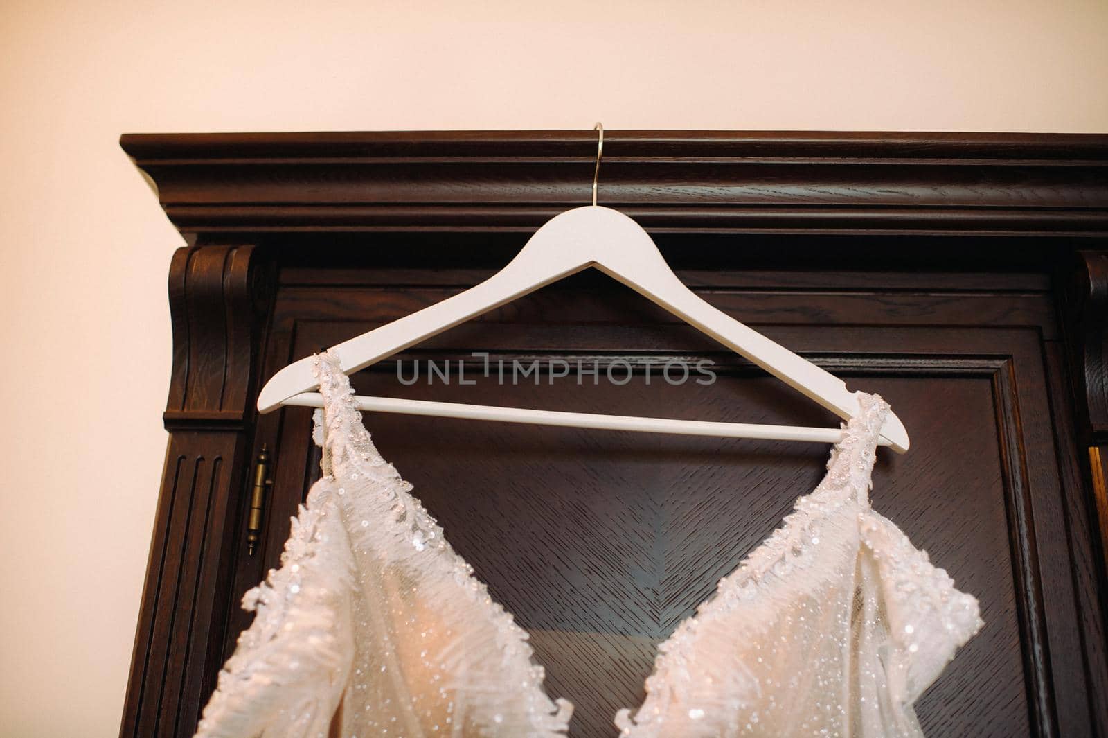 Vintage Wedding dress hanging on a wooden hanger.