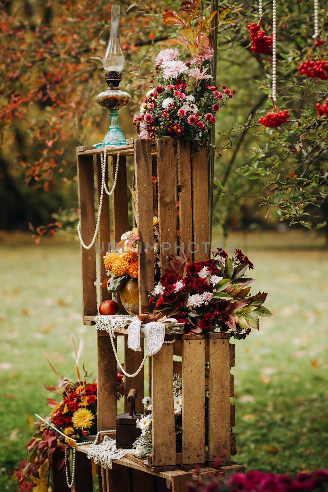 Autumn wedding ceremony on the street on the green lawn.Decor with arches of fresh flowers for the ceremony by Lobachad