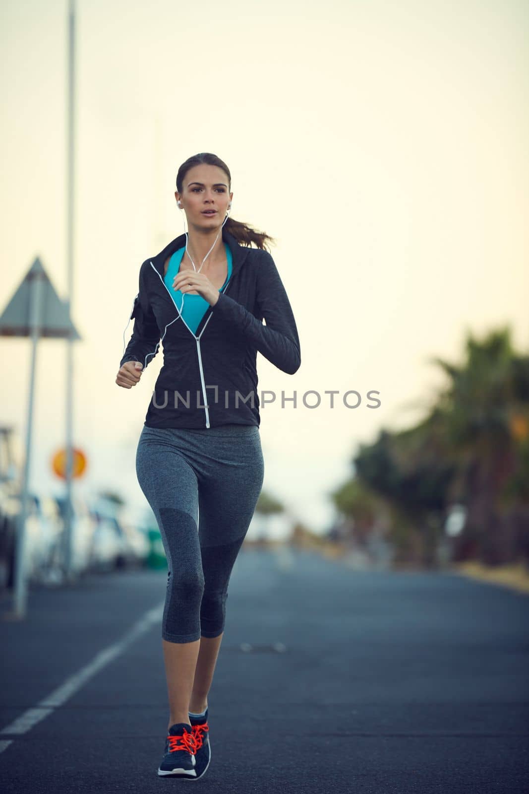 Running can make you feel the most alive. a sporty young woman exercising outdoors. by YuriArcurs