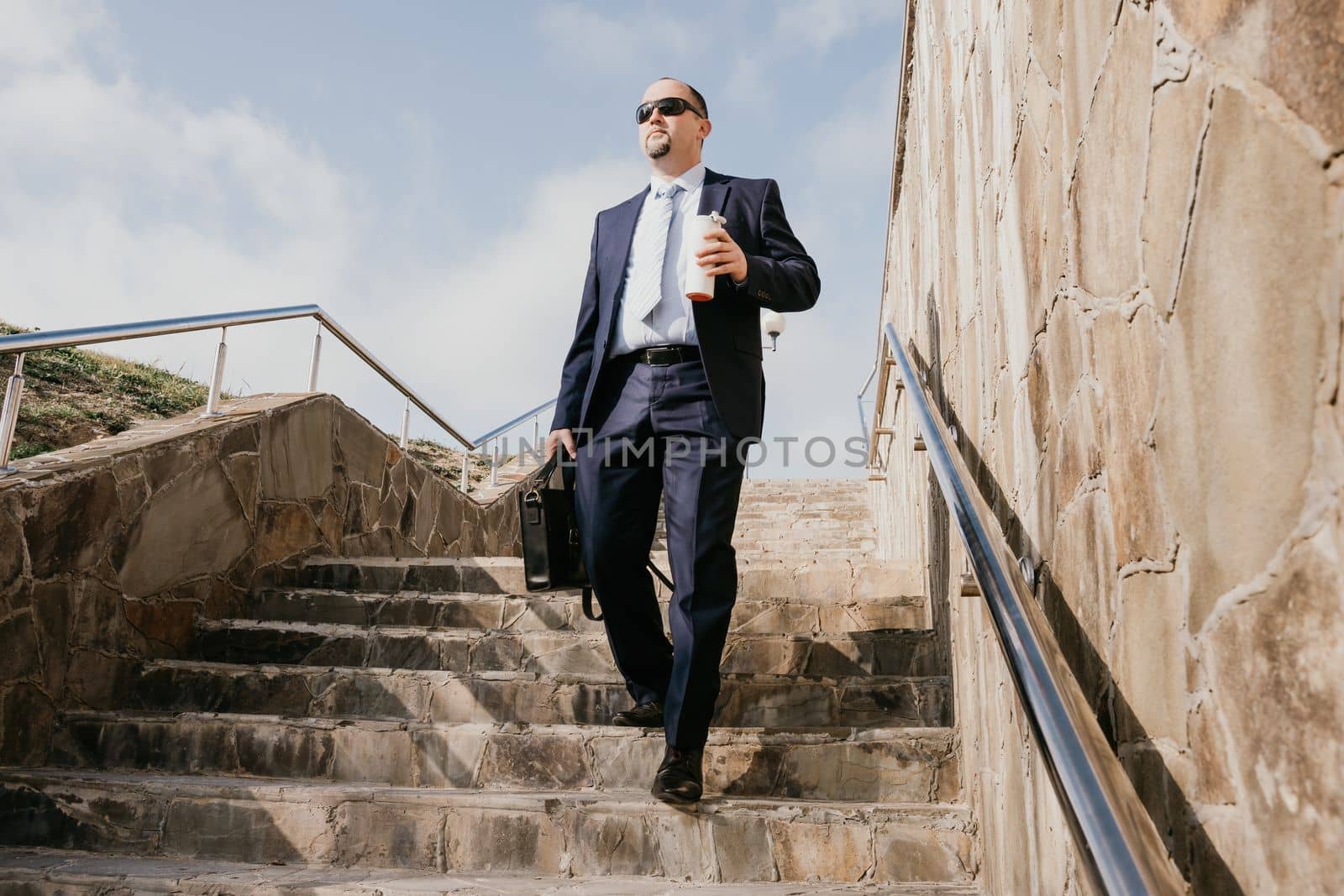 Business executive with briefcase going down the stairs.