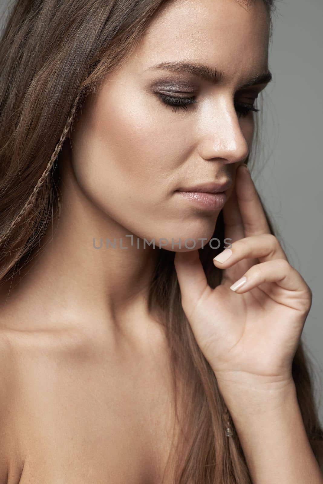 Beauty in simplicity. a beautiful young woman against a gray background