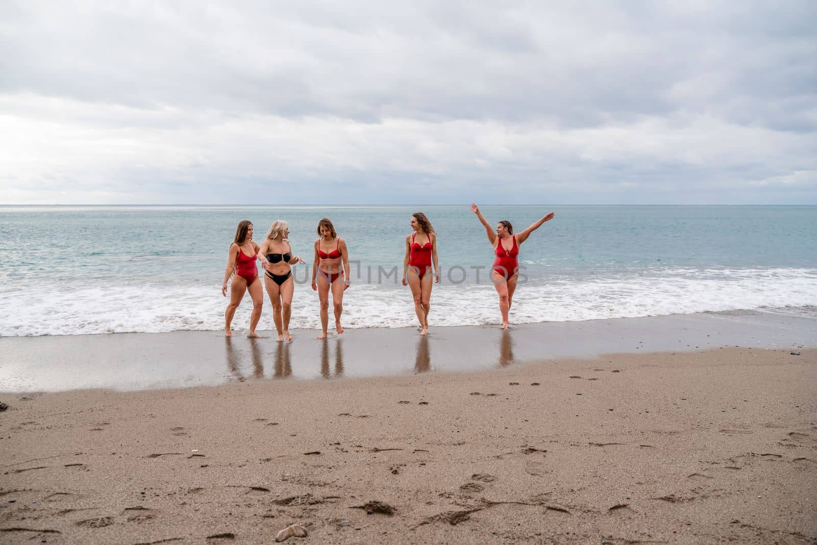 Big happy family or group of five friends is having fun against sunset beach. Beach holidays concept