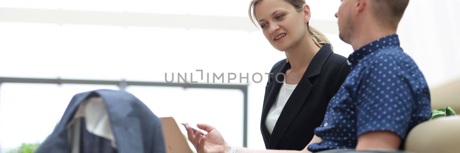 Young businessman is talking to secretary and asking to book tickets online for business trip. Business meeting at airport or hotel