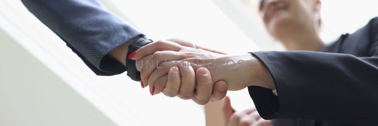 Businessman and woman shaking hands in office closeup. Welcome acquaintance greeting or gratitude gesture concept