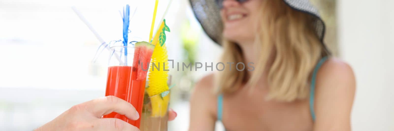 Happy couple in love toasting at resort in hotel. Summer refreshing cocktails concept