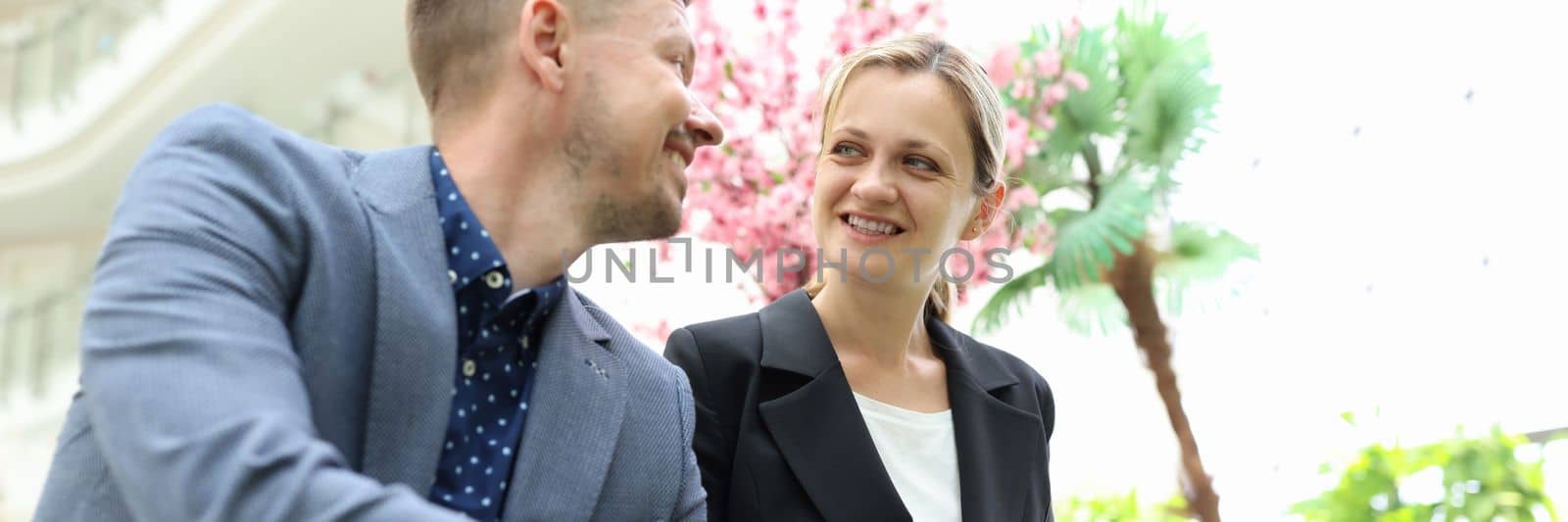 Two business happy smiling people are discussing work and development of startup. Colleagues partners communicate at work