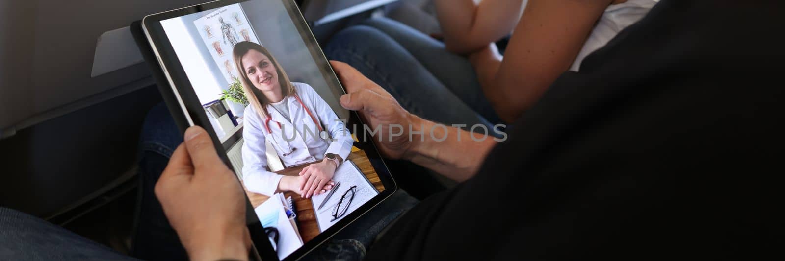 Airplane passengers communicate with doctor remotely via video call. Telemedicine and medical consultation of a general practitioner