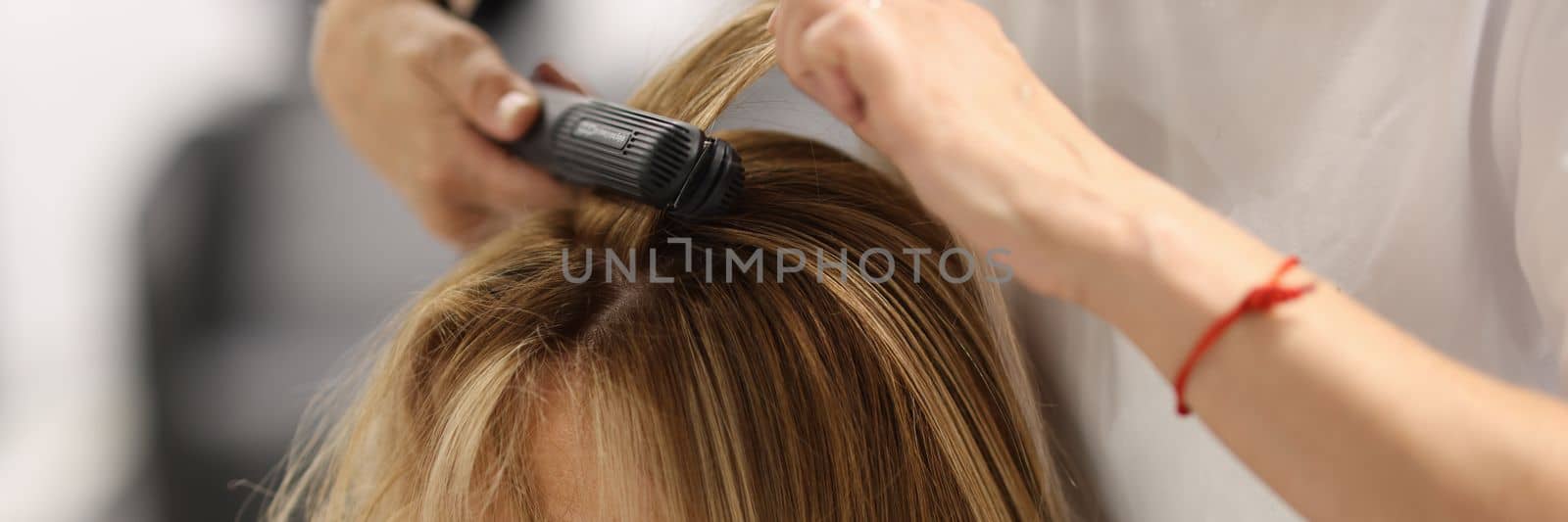 Pulling strands of hair with professional iron care. Keratin straightening and hair restoration