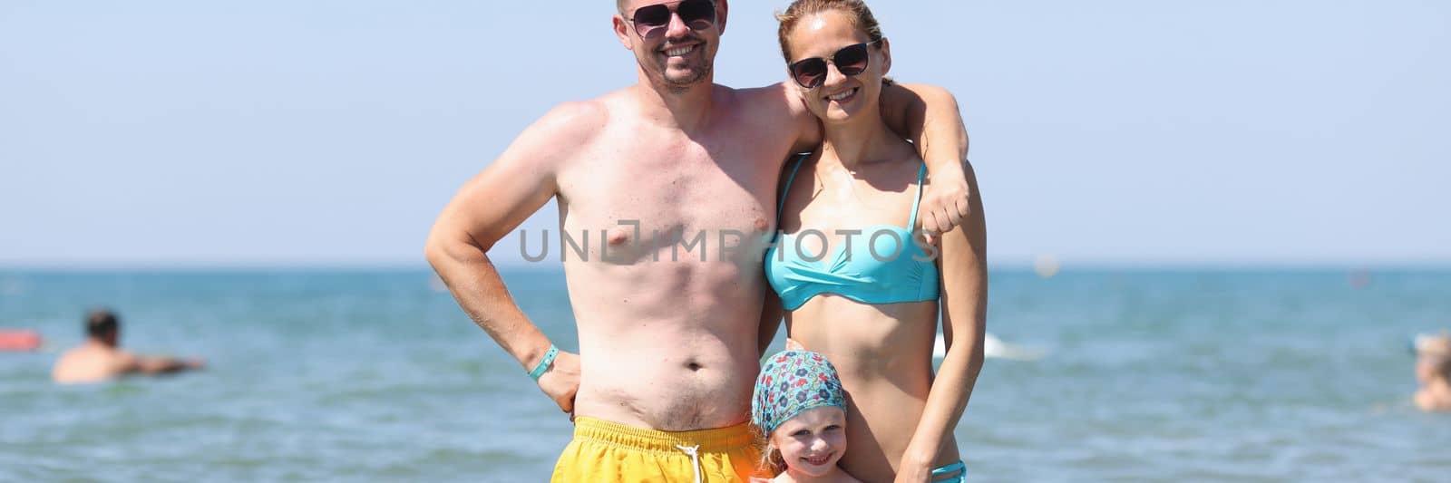 Happy family have fun on beautiful warm sunny beach in sea. Joyful family trips on summer to sea