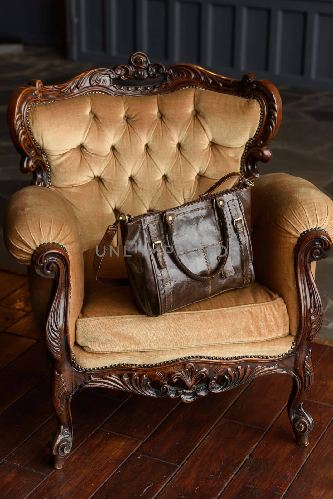 close-up photo of brown leather bag on a yellow velor vintage armchair. indoor photo